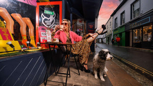 sexy woman drinking coffee outside famous rebel store in Totnes Devon UK
